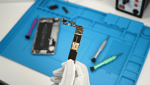 Techniker hält ein iPhone Logicboard in der Hand